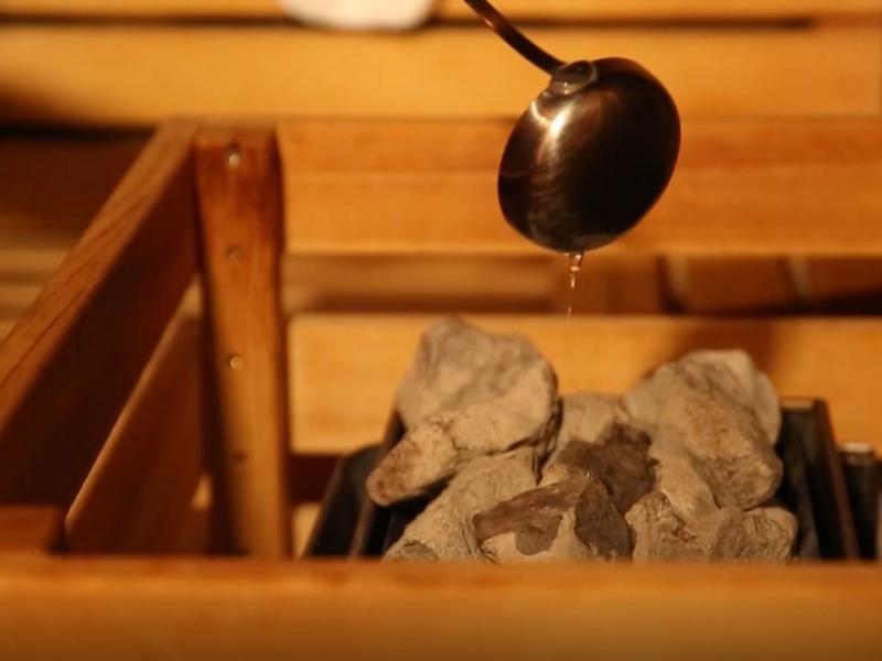 Versamento d'acqua sulle pietre calde di una sauna.